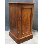 A Victorian mahogany pot cupboard with rounded moulded top above a panelled door, raised on