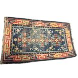 A Turkish rug woven with three floral medallions on blue field framed by greek key style linked