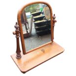 A Victorian mahogany dressing table mirror with arched cushion moulded frame on turned tapering