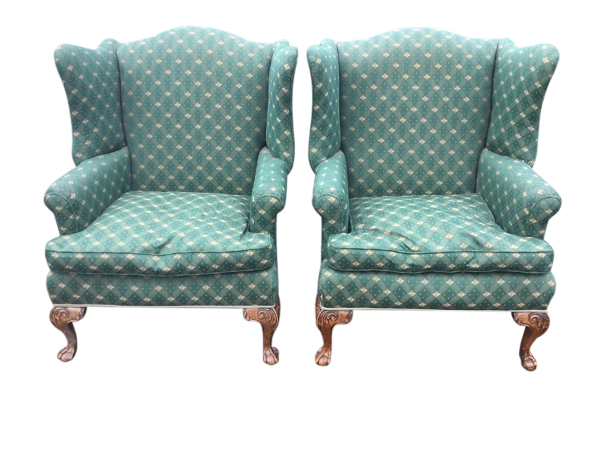 A pair of upholstered Georgian style wing-back armchairs, the wide sprung seats with loose cushions,