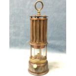 A a miners lamp with circular embossed trademark label The Primer Lamp, with ribbed chimney