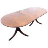 A Georgian style mahogany dining table, the rounded crossbanded top with ribbed edge supported on