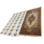 A Persian style wool rug woven with oval floral medallion on fawn field bordered by scalloped