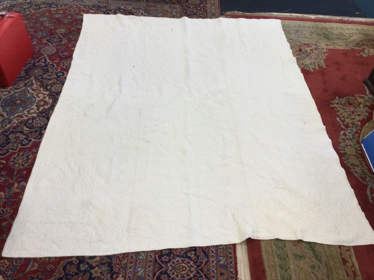 A large white cotton Durham quilt, hand-sewn in an embossed floral quilted pattern. (78in x 104in)