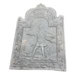 A cast iron fireback with bead framed arched panel of a fighting young soldier holding sword &