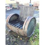 A garden armchair formed out of an old barrel, the back and seat with slatted staves, cut into a