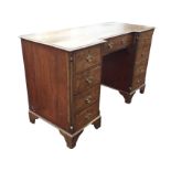 A nineteenth century mahogany kneehole desk, the breakfront rectangular moulded top above a