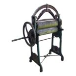 A Victorian cast iron mangle by J & A McFarlane Ltd, the arched spring above wood rollers turned