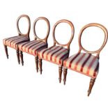 A set of four Victorian mahogany balloon-back dining chairs with stuffover upholstered seats