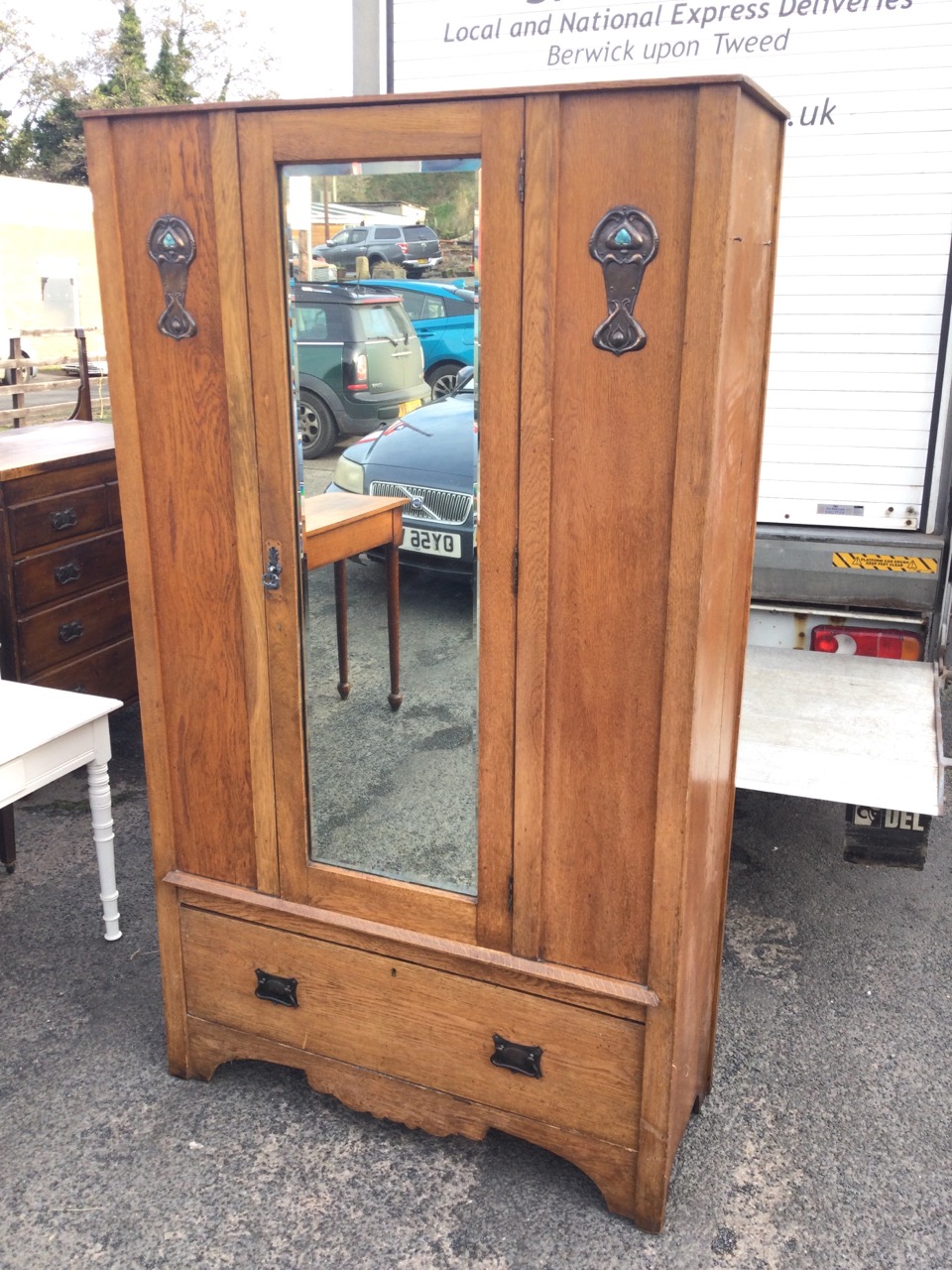 An art nouveau oak wardrobe with central bevelled mirror door framed by panels with applied anodised - Image 2 of 3