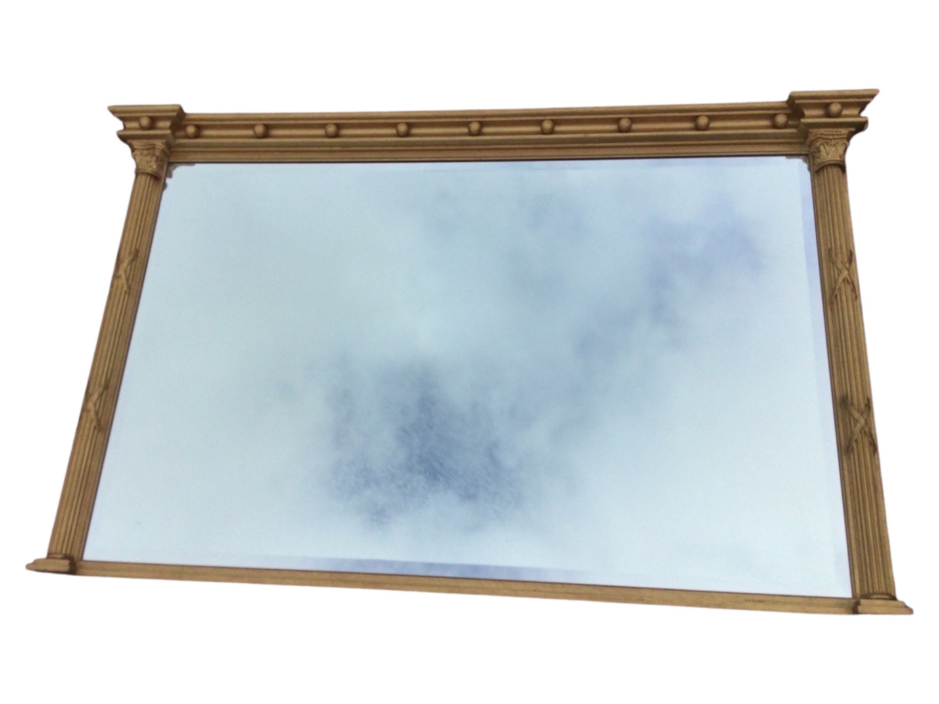 A regency style gilt overmantle mirror with bevelled plate, the concave moulded cornice mounted with