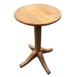 A circular country oak occasional table supported on a square column, with quadripartite shaped