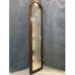 A mahogany framed mirror with arched bevelled plate. (45.75in x 11.5in)