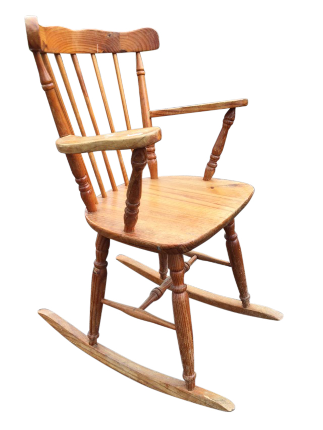 A pine rocking chair with spindle back and tapering platform arms, the solid seat raised on turned