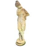 A composition stone garden statue cast as a lady hiding her modesty with draped clothing and