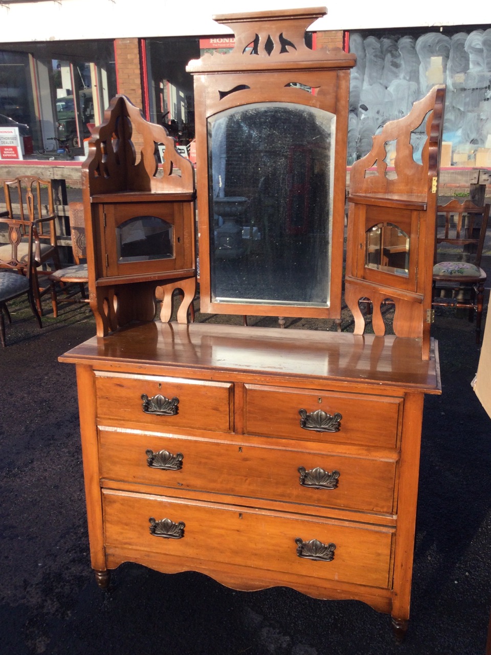 A late Victorian satin walnut dressing table with pierced fretwork above bevelled plates, the