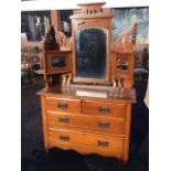 A late Victorian satin walnut dressing table with pierced fretwork above bevelled plates, the