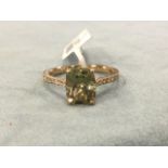 An 18ct gold turkizite ring, the cushion cut rectangular raised claw set stone bordered by