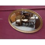 Oval bevelled wall mirror in gilt frame with beaded decoration, 98cm x 65cm