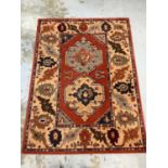 Large rug with geometric decoration on red, blue and beige ground, 326cm x 174cm