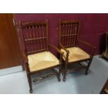 Set of six oak spindle back chairs with rush seats comprising four standards and two carvers