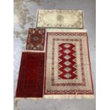 Eastern rug with geometric decoration on red, blue and cream ground, 150cm x 98cm and three smaller