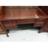 Oriental hardwood kneehole writing table with plate glass top and five drawers below, 122cm wide, 61