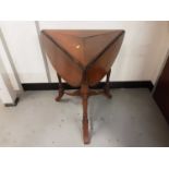 Late Victorian walnut drop flap table of triangular form with ring turned supports joined by stretch