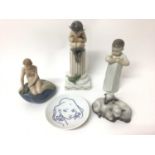 Four Royal Copenhagen porcelain figures, including a fawn sat on a plinth, a child, two lambs and a