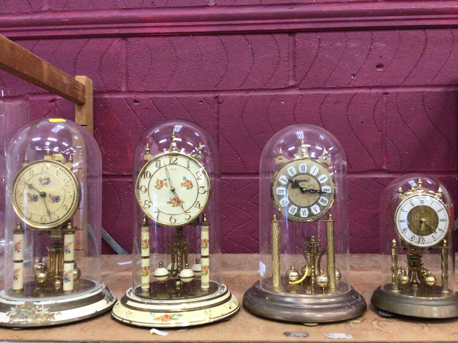 Four glass domed clocks