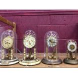 Four glass domed clocks