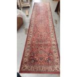 Eastern runner with floral decoration on pink and cream ground, 347.5cm x 83cm