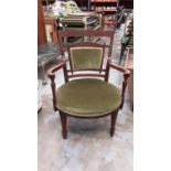 Late Victorian low walnut framed elbow chair with green upholstered seat and back, on square taper f