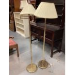 Two brass standard lamps with shades