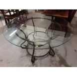 Large good quality circular dining table with glass top on wrought metal base