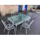 Wrought iron garden table with glass top and a set of four matching chairs