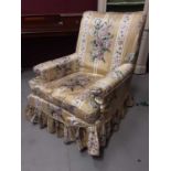 Victorian armchair with loose floral cover on turned front legs and brass castors, 77cm wide, 85cm d