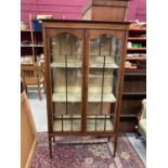 Edwardian inlaid mahogany display cabinet with shelved interior enclosed by two glazed doors on squa