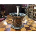 Antique bell metal pestle and mortar, the mortar which a raised fleur-de-lys on each side, the pestl