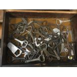 Collection of vintage bottle openers in wooden cabinet
