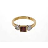 Garnet and diamond three stone ring with a square step cut garnet flanked by two round brilliant cut