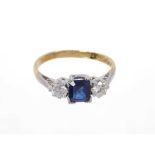 Sapphire and diamond three stone ring with a rectangular step cut blue sapphire flanked by two roun