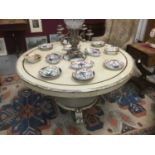 Antique cream painted circular breakfast table, with oval tilt top on bulbous faceted column and cas
