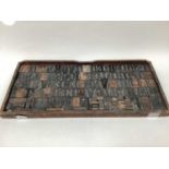 Collection of old wooden printing blocks in a large wooden tray