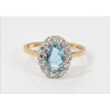 18ct gold aquamarine and diamond cluster ring with an oval mixed cut aquamarine surrounded by twelve