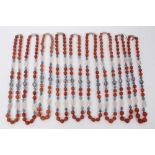 Nine Chinese carnelian bead necklaces interspaced with enamelled beads and pink hard stones, all wit