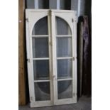 Set of three antique white painted eight pane arched doors, each with locking bar, 204 x 104cm