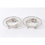 Pair of 1930s silver bon-bon dishes, with pierced flared borders, on four decorative feet