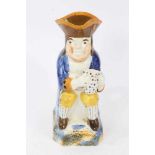 Prattware Toby jug, circa 1800, seated and holding frothing jug of beer, decorated in typical colour