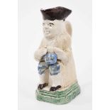 Creamware Toby jug, circa 1790, shown seated, holding a frothing jug of beer, wearing a cream jacket